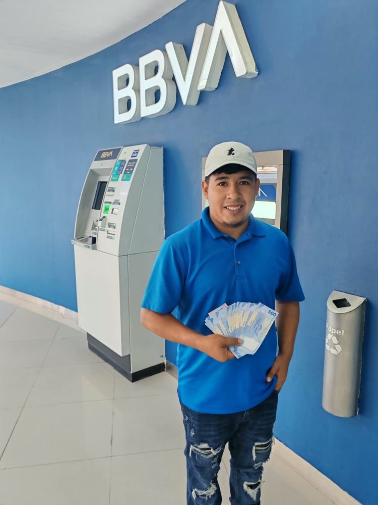 Cliente con su dinero junto a un cajero